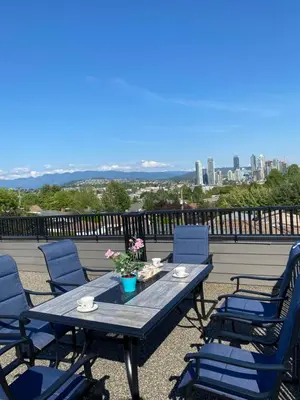 a table and chairs on a balcony with a view of the city at Six minutes to Rupert station in Vancouver