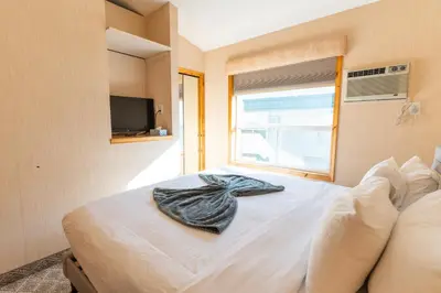 a bedroom with a bed with a towel on it at BANFF WOODS LODGE in Canmore