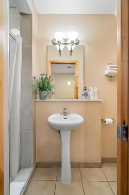 a bathroom with a sink and a mirror at BANFF WOODS LODGE in Canmore