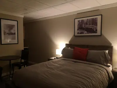 a bedroom with a bed and a table with a chair at The Cache Hotel and Lodgings in Golden