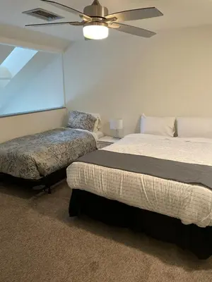 a bedroom with two beds and a ceiling fan at Hearthstone Lodge loft, Village centre, Private Hot tub, sleeps 6 in Whistler