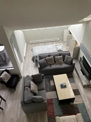 a living room with a couch and a table at Hearthstone Lodge loft, Village centre, Private Hot tub, sleeps 6 in Whistler