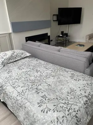 a bed in a living room with a couch at Hearthstone Lodge loft, Village centre, Private Hot tub, sleeps 6 in Whistler
