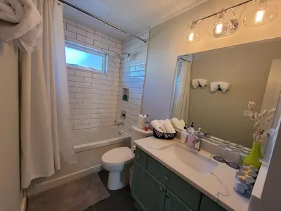 a bathroom with a sink and a toilet and a tub at JoyVeal’s Homey Place in Sechelt