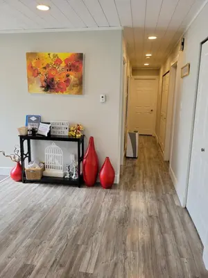a hallway with wood floors and red vases at JoyVeal’s Homey Place in Sechelt