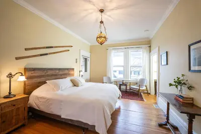 a bedroom with a white bed and a table and chairs at The Copeland in Revelstoke