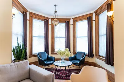 a living room with chairs and a table and windows at The Copeland in Revelstoke