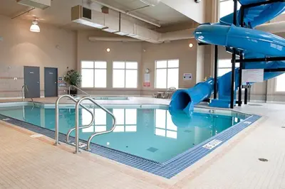 a pool with a water slide in a building at Paradise Inn and Suites in Valleyview