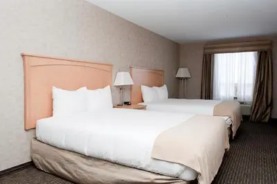 a hotel room with two beds and a window at Paradise Inn and Suites in Valleyview