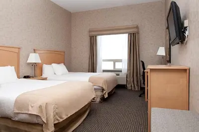 a hotel room with two beds and a television at Paradise Inn and Suites in Valleyview