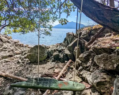 a swing on a rocky beach near the water at Maple Rise Guesthouse in Duncan