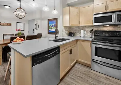 a kitchen with a sink and a stove top oven at Newly Renovated Grizzly Lodge, Spacious 3BR 2BA with open pool, hot tub in Canmore