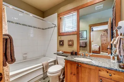 a bathroom with a tub and a toilet and a sink at Mountain Star 28 Hot Tub in Whistler