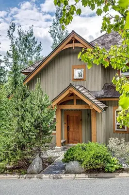 a house with a wooden door in a yard at Mountain Star 28 Hot Tub in Whistler