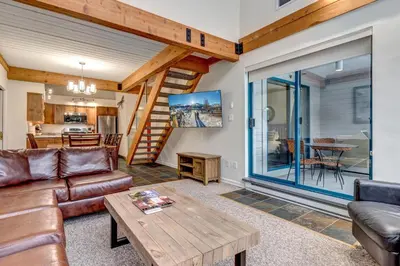 a living room with a couch and a table at Greystone Lodge 413 - Largest in Whistler
