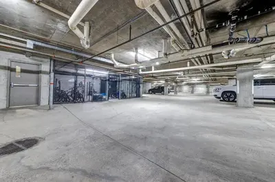 an empty parking garage with a white van parked in it at Greystone Lodge 333 Ski-in Out in Whistler