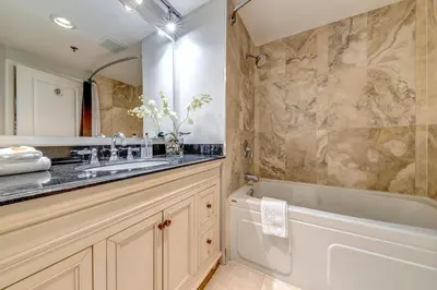 a bathroom with a tub and a sink and a bath tub at Greystone Lodge 333 Ski-in Out in Whistler