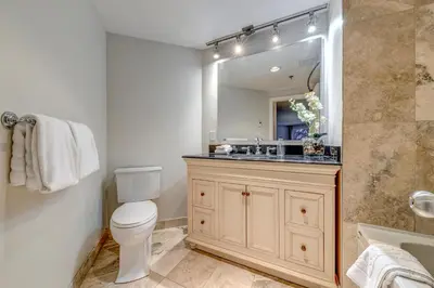 a bathroom with a toilet and a sink and a mirror at Greystone Lodge 333 Ski-in Out in Whistler