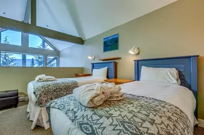a bedroom with two beds and a window at Greystone Lodge 310 Ski-in Out in Whistler