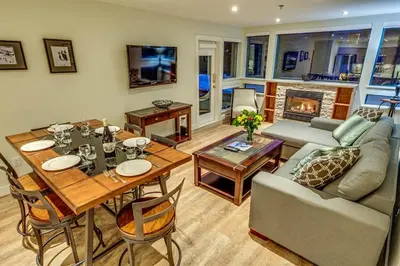 a living room with a table and a couch at Greystone Lodge 109 Ski-in Out in Whistler