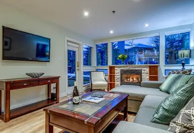 a living room with a couch and a fireplace at Greystone Lodge 109 Ski-in Out in Whistler