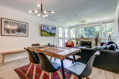 a living room with a table and chairs and a couch at Greystone Lodge 328 Ski-in Out in Whistler