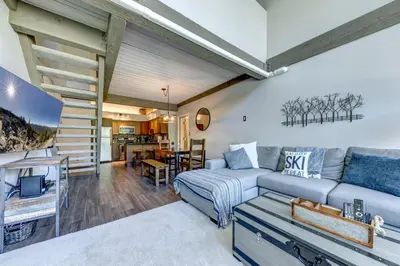 a living room with a couch and a staircase at Greystone Lodge 412 Renovated in Whistler
