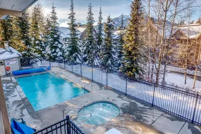 a swimming pool in the snow on a house at Greystone Lodge 412 Renovated in Whistler