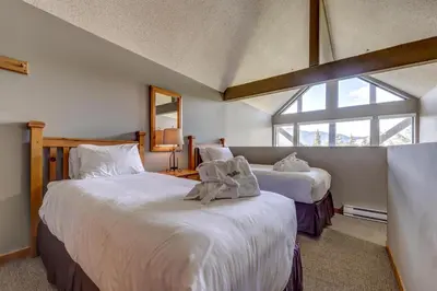 a bedroom with two beds and a window at Greystone Lodge 311 Ski-in Out in Whistler