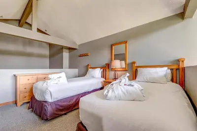 a bedroom with two beds with white sheets at Greystone Lodge 311 Ski-in Out in Whistler