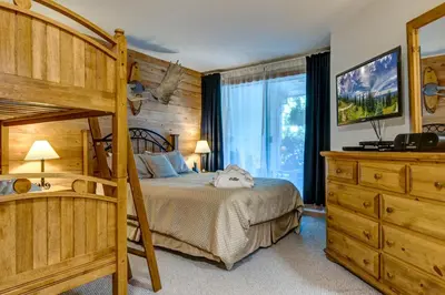 a bedroom with a bunk bed and a dresser at Greystone Lodge 229 Ski-in Out in Whistler