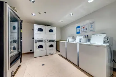 a laundry room with white machines and a counter at Greystone Lodge 229 Ski-in Out in Whistler