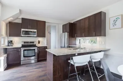 a kitchen with wooden cabinets and stainless steel appliances at West Coast Luxury Living in Vancouver