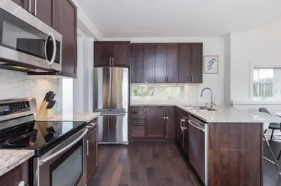a kitchen with wooden cabinets and stainless steel appliances at West Coast Luxury Living in Vancouver