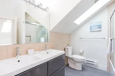 a bathroom with a white sink and a toilet at West Coast Luxury Living in Vancouver