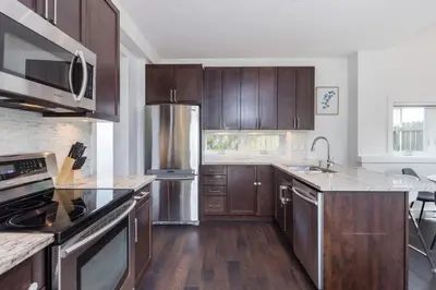 a kitchen with wooden cabinets and stainless steel appliances at West Coast Luxury Living in Vancouver