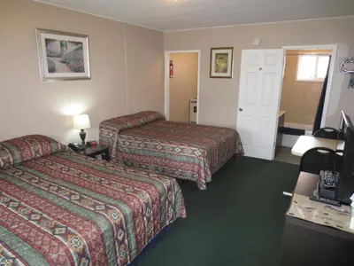 a hotel room with two beds and a television at Overlander Motel in Chase