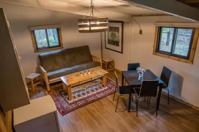 a living room with a couch and a table at Chute Lake Lodge in Naramata