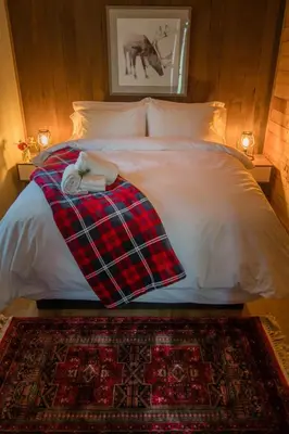 a bed with a blanket and a robe on it at Chute Lake Lodge in Naramata