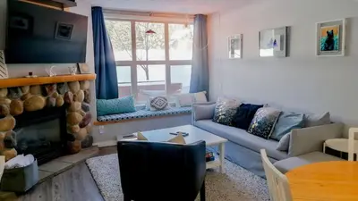 a living room with a couch and a fireplace at Crystal Forest #29 by Bear Country in Sun Peaks