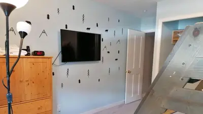 a living room with a tv on a wall with black butterflies at Crystal Forest #29 by Bear Country in Sun Peaks