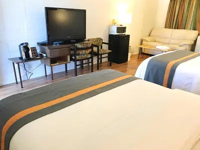 a hotel room with two beds and a flat screen tv at Duncan Motel in Duncan
