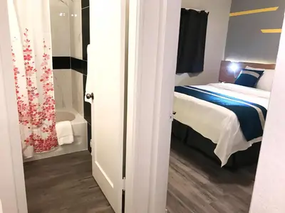 a small bedroom with a bed and a tub at Duncan Motel in Duncan