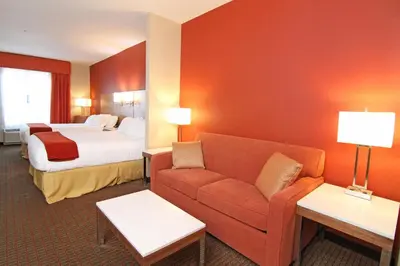 a hotel room with a couch and a bed at Holiday Inn Express and Suites Calgary University by IHG in Calgary