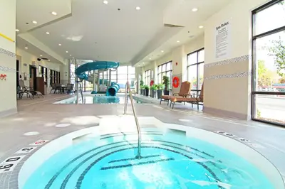 a large swimming pool in a building with a slide at Holiday Inn Express and Suites Calgary University by IHG in Calgary