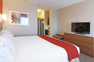 a hotel room with a bed and a flat screen tv at Holiday Inn Express and Suites Calgary University by IHG in Calgary