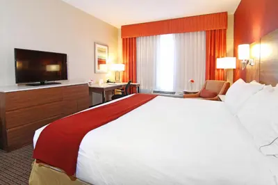a hotel room with a large bed and a flat screen tv at Holiday Inn Express and Suites Calgary University by IHG in Calgary
