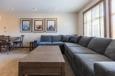 a living room with a couch and a table at Snow Creek Lodge by Fernie Central Reservations in Fernie