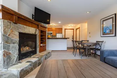 a living room with a fireplace and a table with chairs at Snow Creek Lodge by Fernie Central Reservations in Fernie