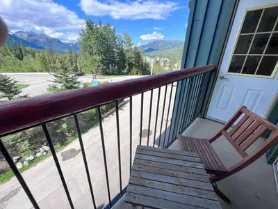 a porch with a wooden bench on a balcony at Snow Creek Lodge by Fernie Central Reservations in Fernie